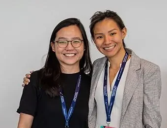 Two exhibitors smiling together at their stand